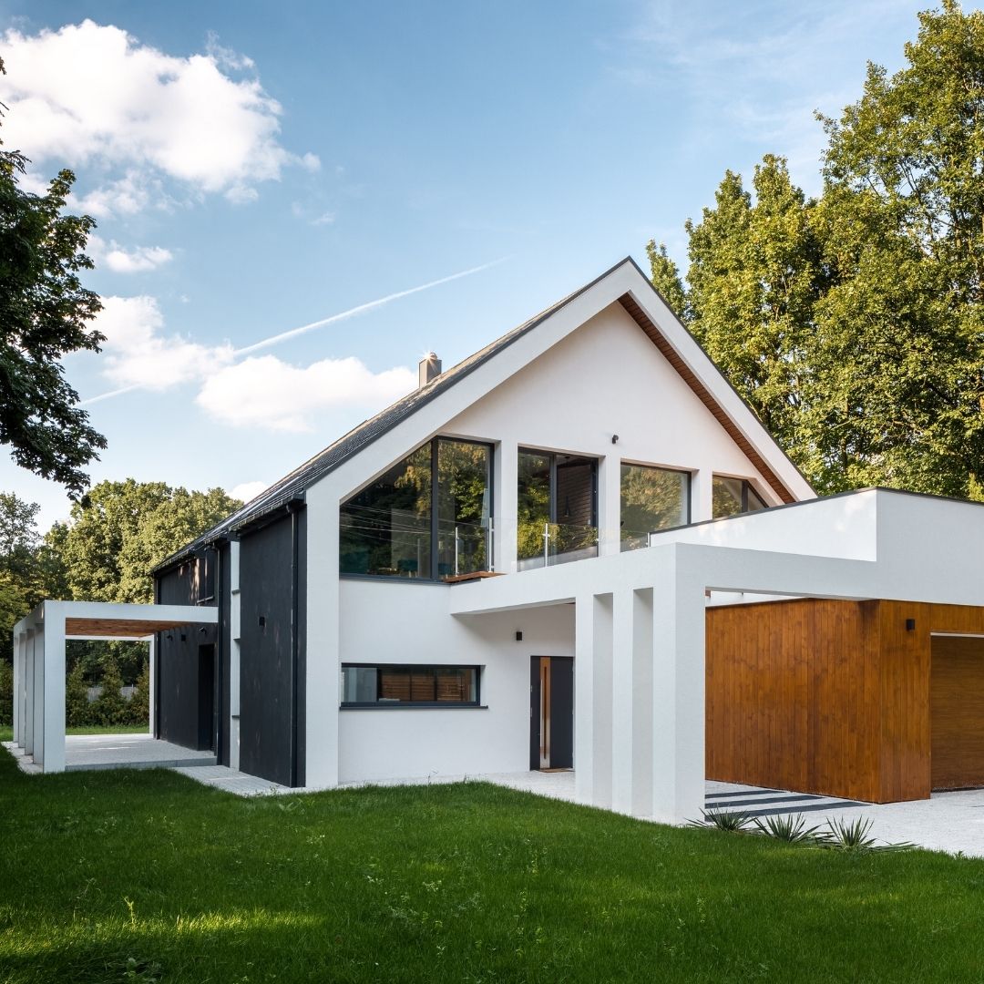 Minimalist modern landscape design in Boston featuring a clean, level green lawn and a white gravel driveway area.